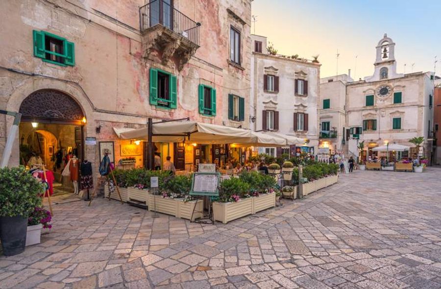 Rue pittoresque dans le centre historique de Polignano a Mare avec ses bâtiments aux façades colorées.