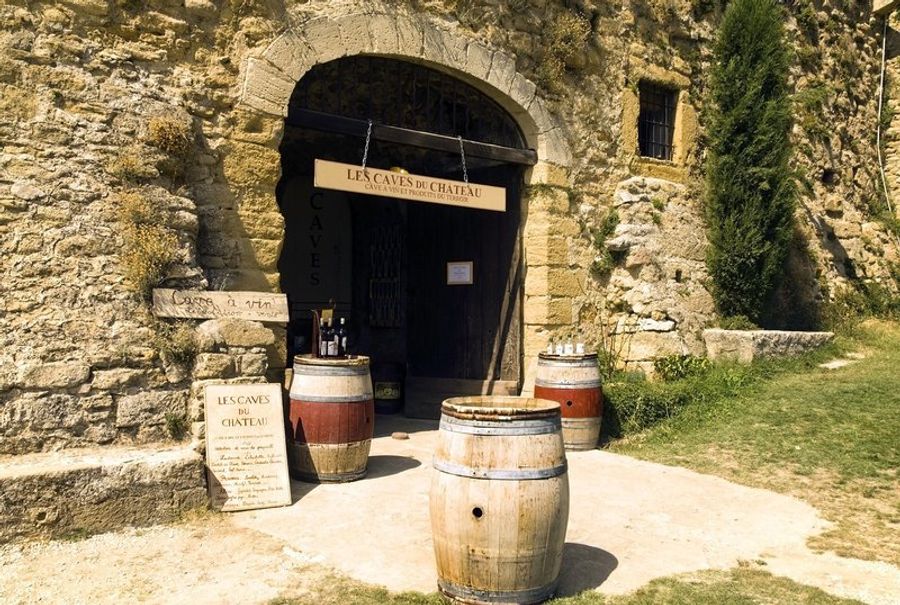 Entrée d’une cave à vins typique du Luberon, mettant en valeur des tonneaux en bois.