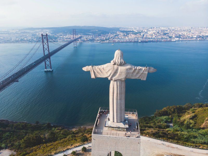 La statue emblématique du Cristo Rei surplombant le pont du 25 Avril à Almada, Portugal.