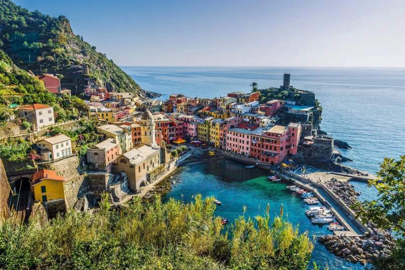 Vue panoramique du village pittoresque de Vernazza avec ses maisons colorées, son port naturel et les eaux turquoise de la mer des Cinque Terre.