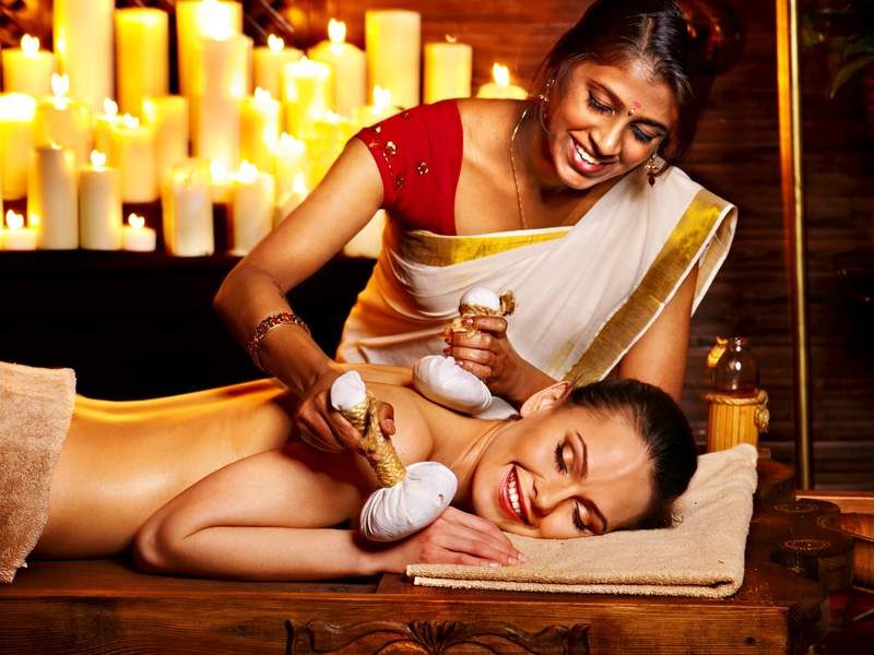 Massage ayurvédique dans un spa sri-lankais avec lumière tamisée.