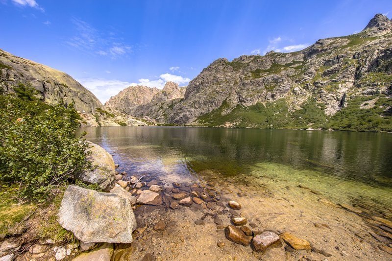La vallée de la Restonica en Corse avec ses piscines naturelles et ses montagnes verdoyantes.