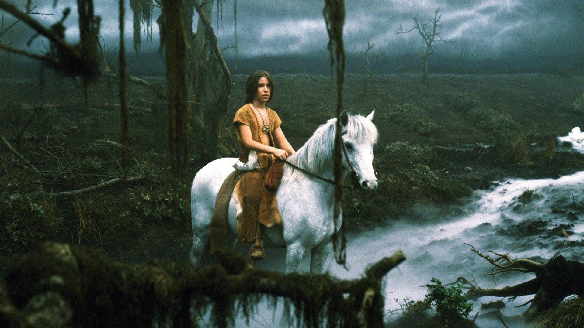 a boy on a white horse in a swamp