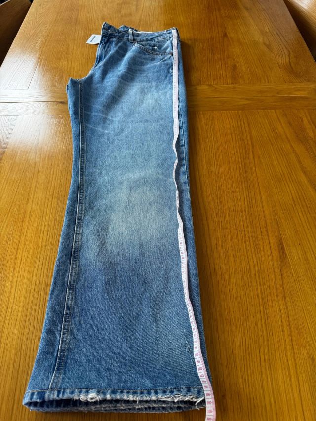 The new jeans before: far too long, a tape measure laid along the leg
