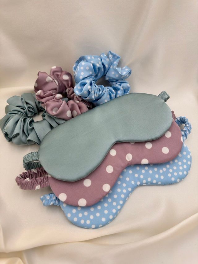 Three sleep masks in sage, pink polka dot and blue polka dot with matching scrunchies