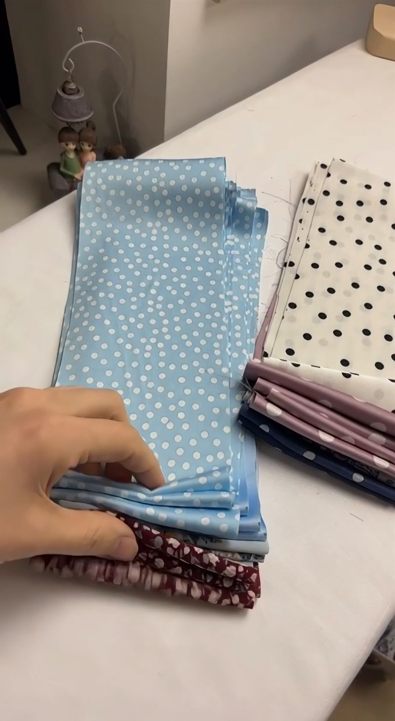 Stacks of cut fabric in polka dots and florals, sorted on the table