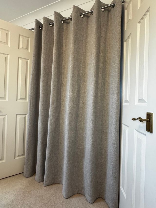 The grey eyelet curtain after, hanging straight to the floor