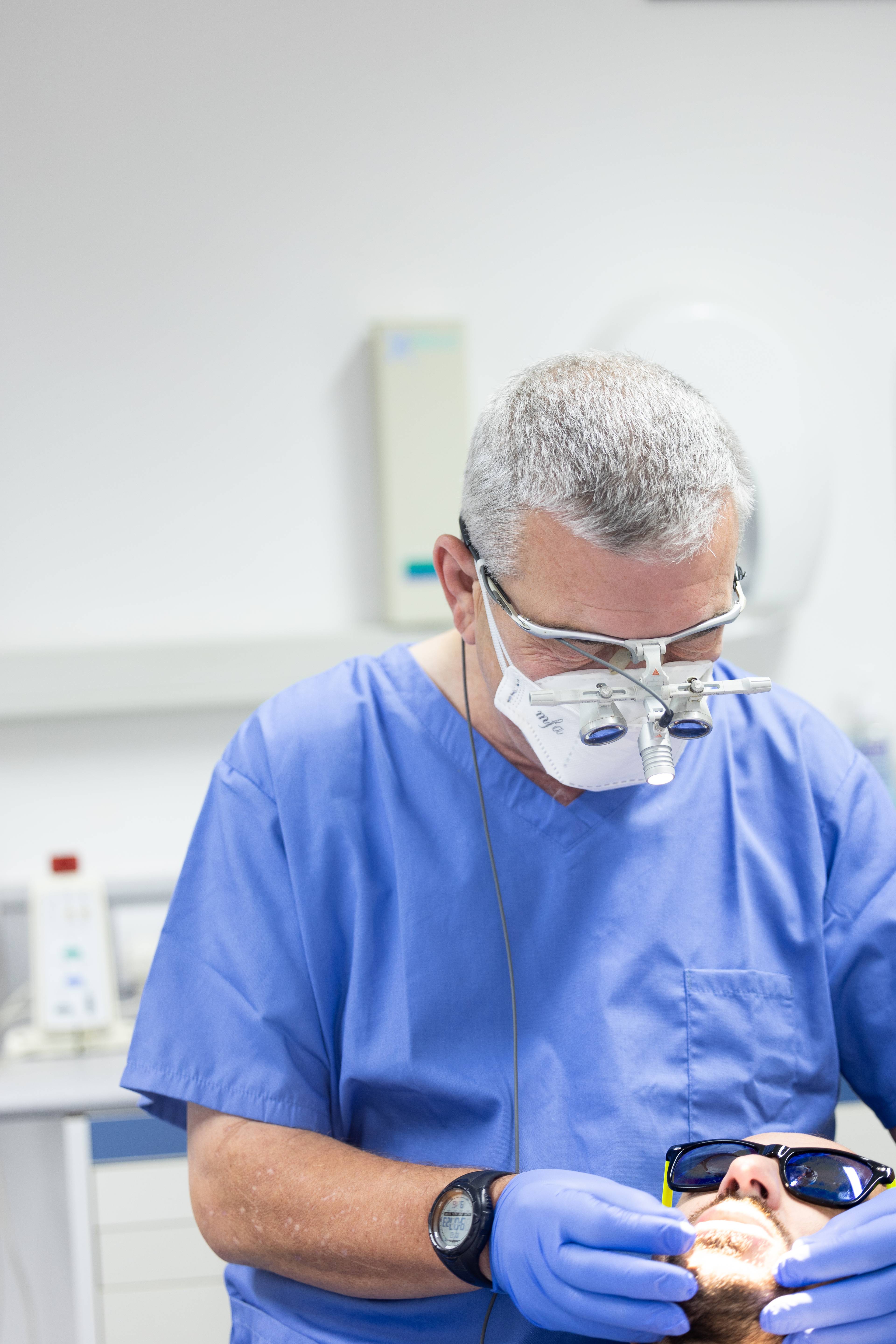 Pontcanna Dental Care dentist wearing scrubs and loops whilst treating patient in a clean surgery