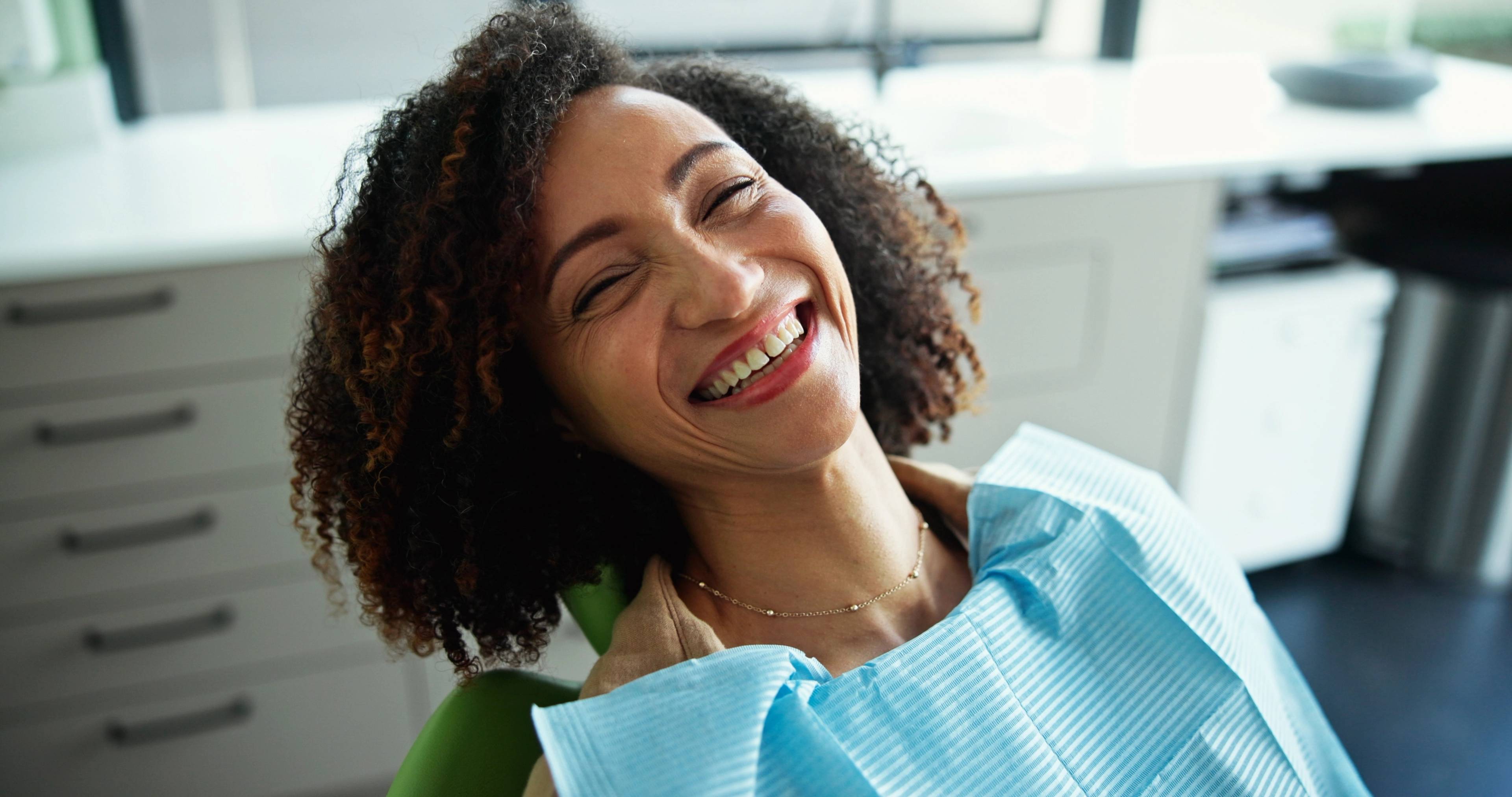Patient smiling on the chair during a dental exam