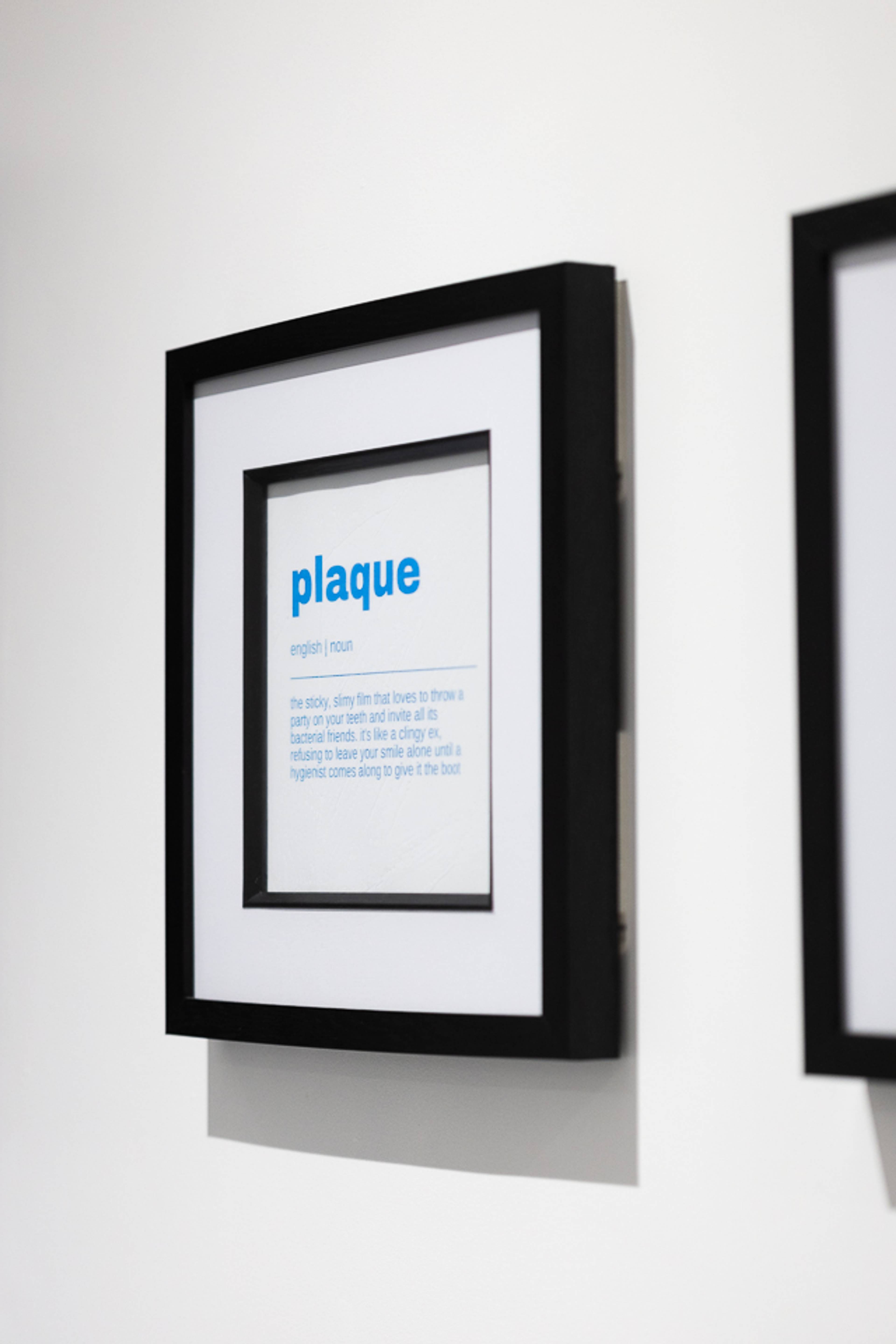 Black and white picture frame featuring the words "plaque" hanging on the wall at Pontcanna Dental