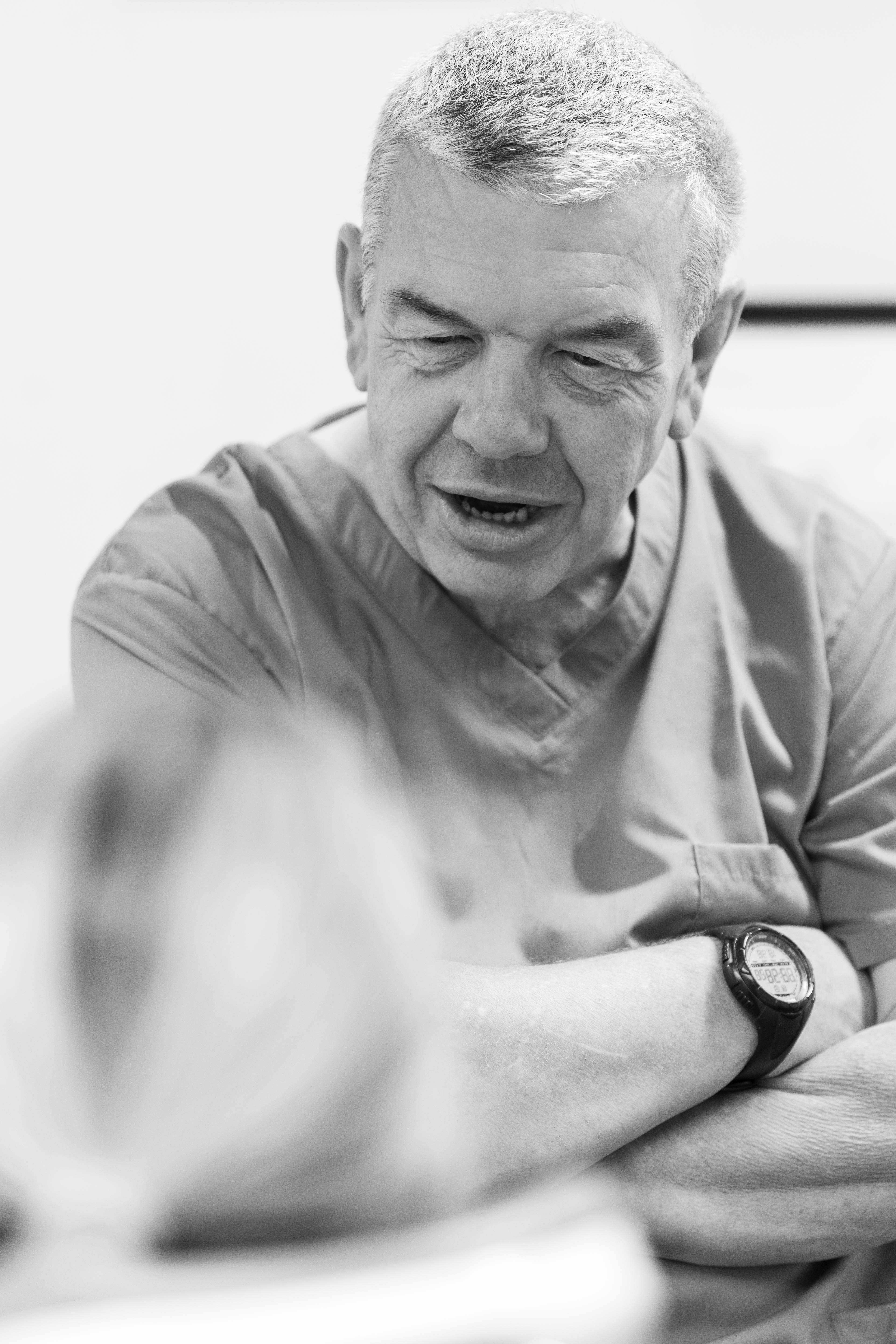 black and white photo of dentist talking to patient in dental practice