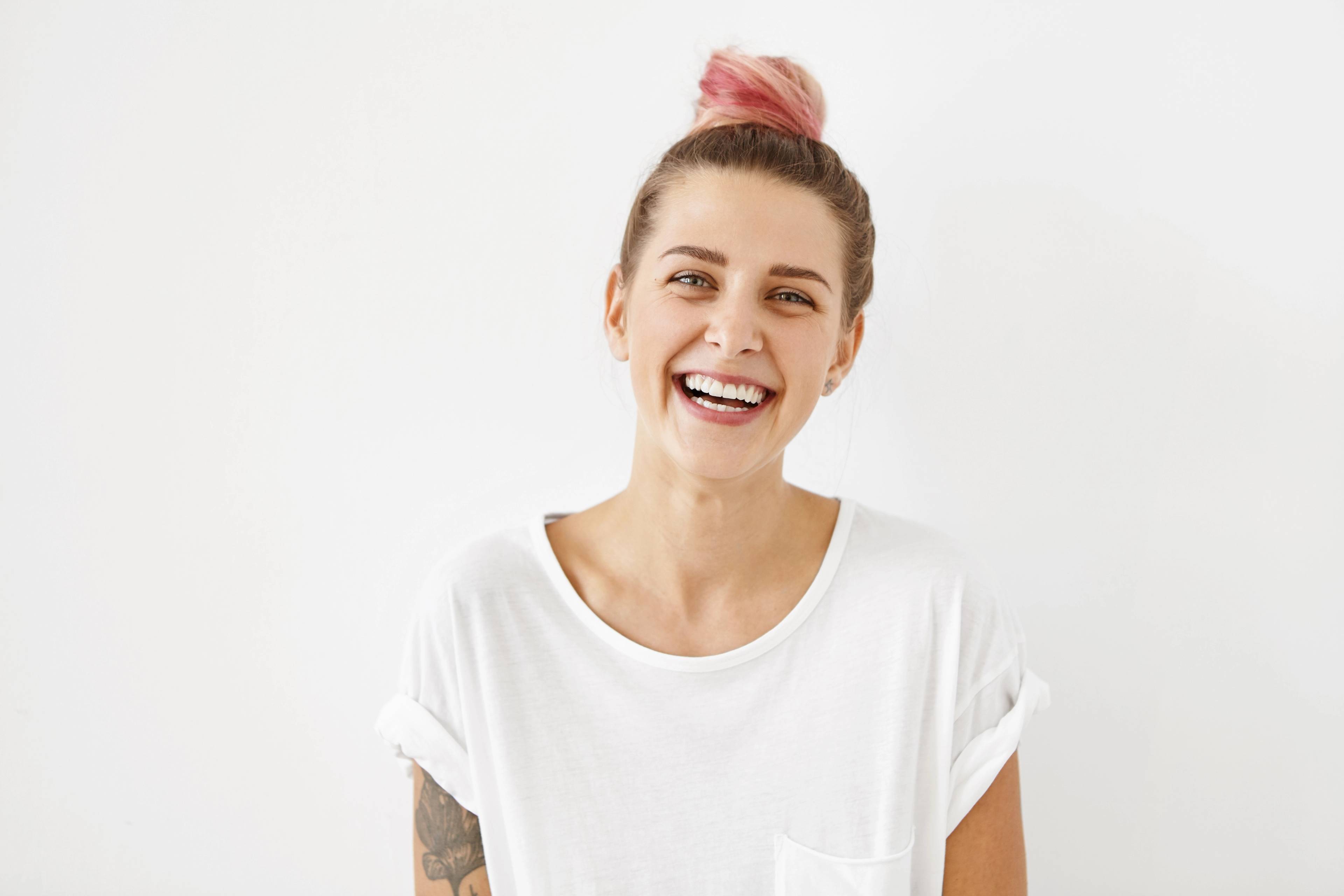 head and shoulders photo young female patient in white t-shirt smiling against a light background
