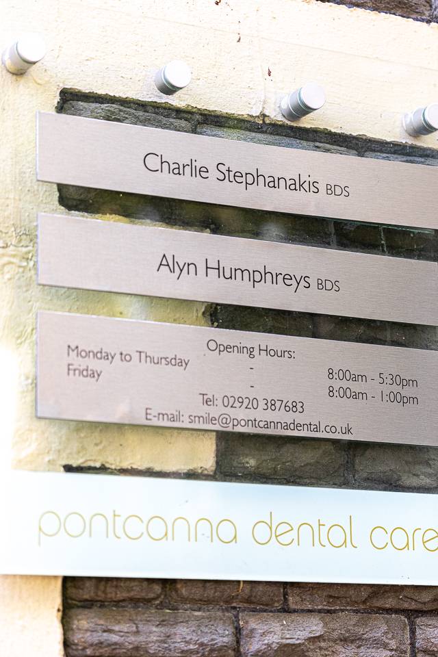 outdoor signage at pontcanna dental showing dentist names, titles and business opening hours