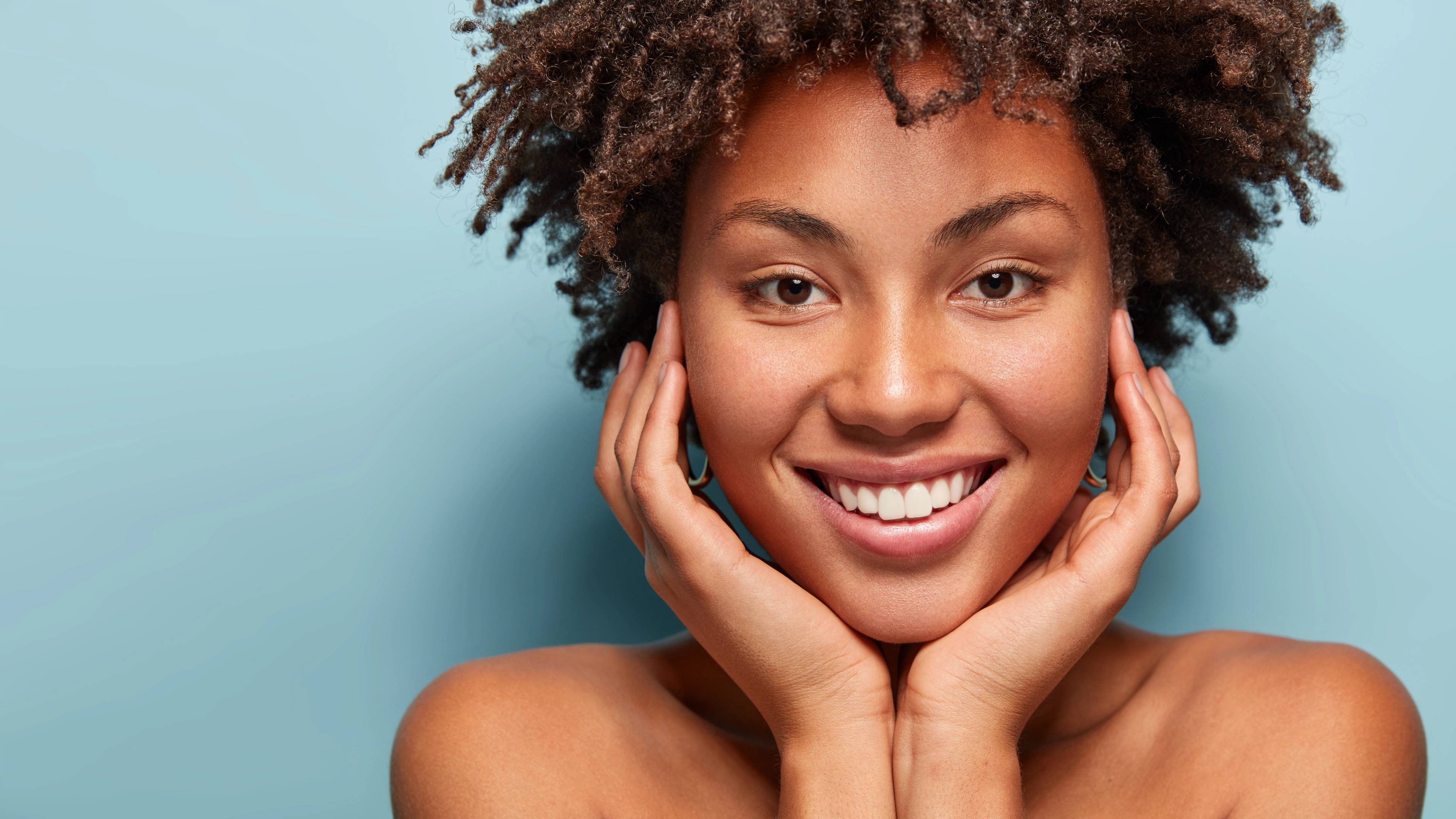 female patient smiling against blue background