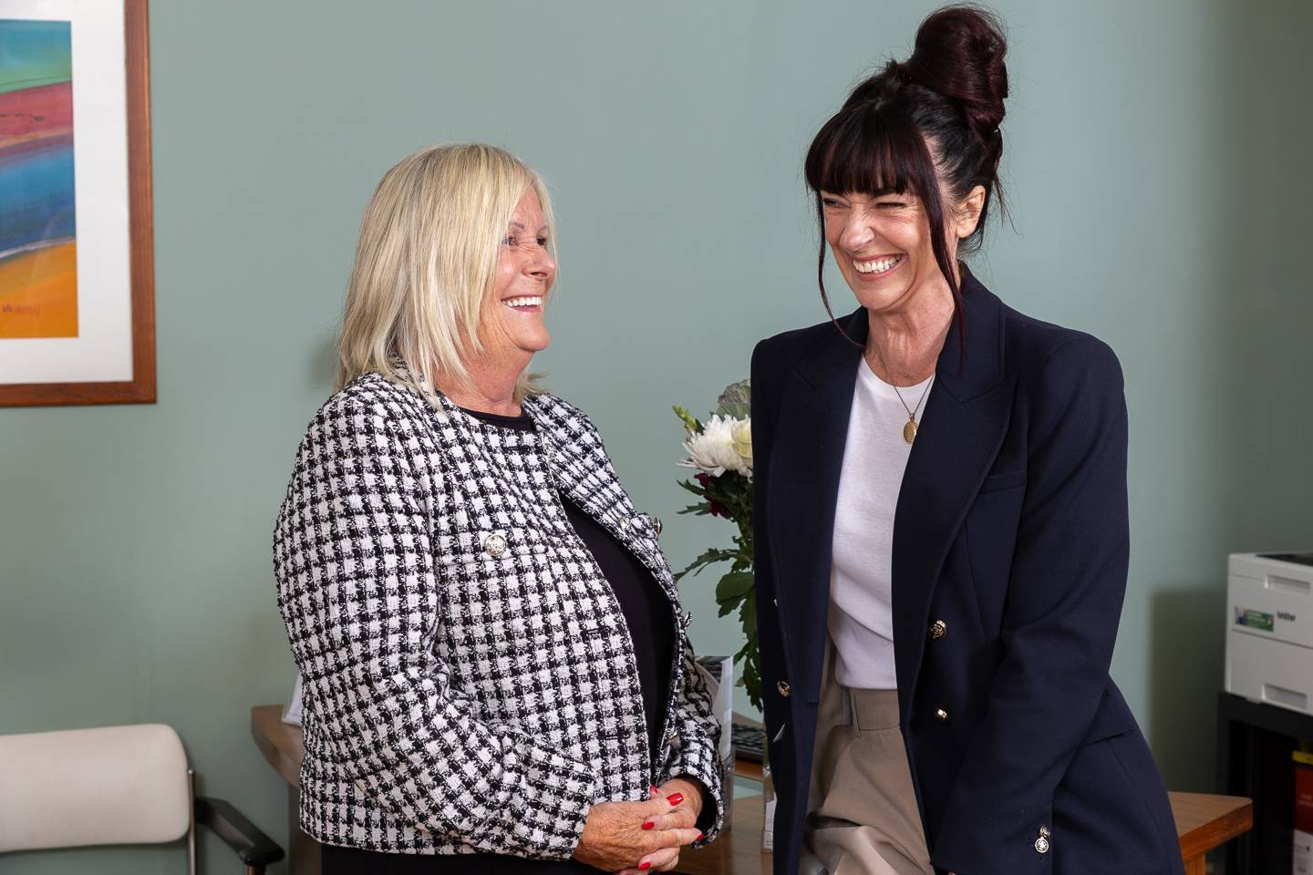 Two receptionist dressed professionally laughing together in reception