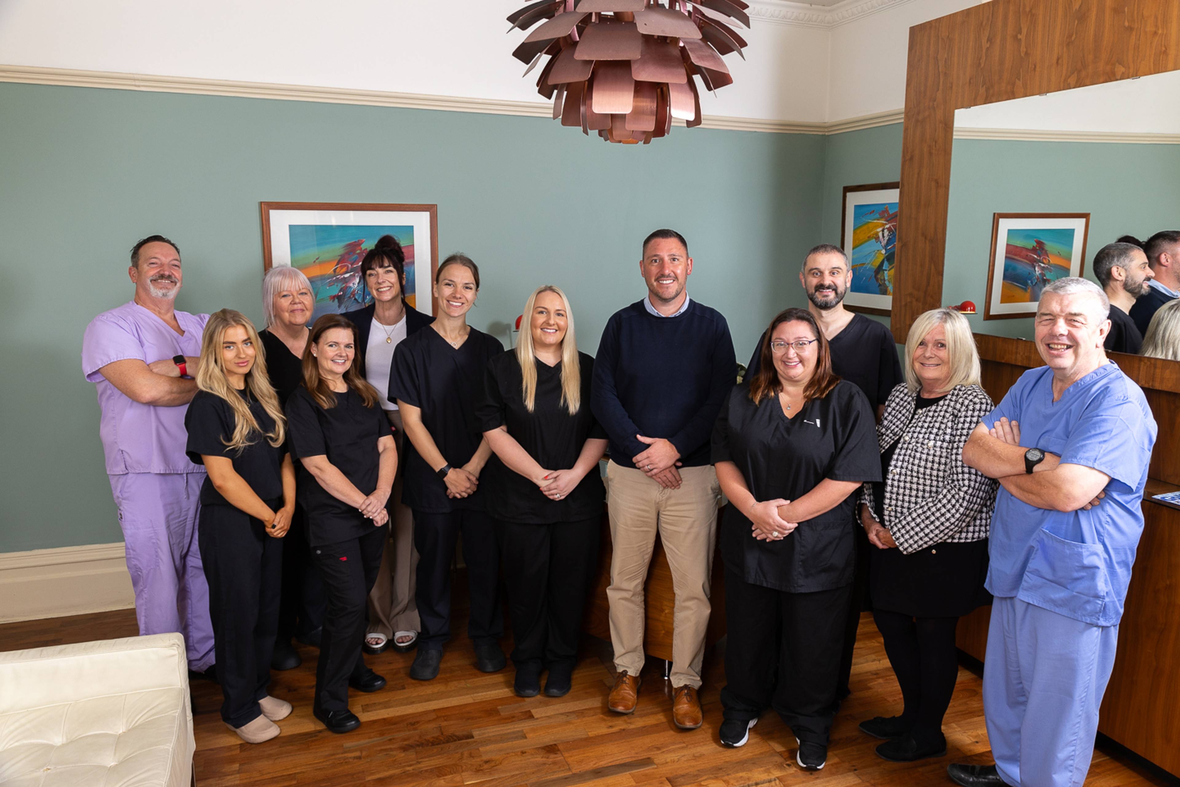 The team of dental professionals at Pontcanna dental care standing smiling for a photo in their patient waiting area