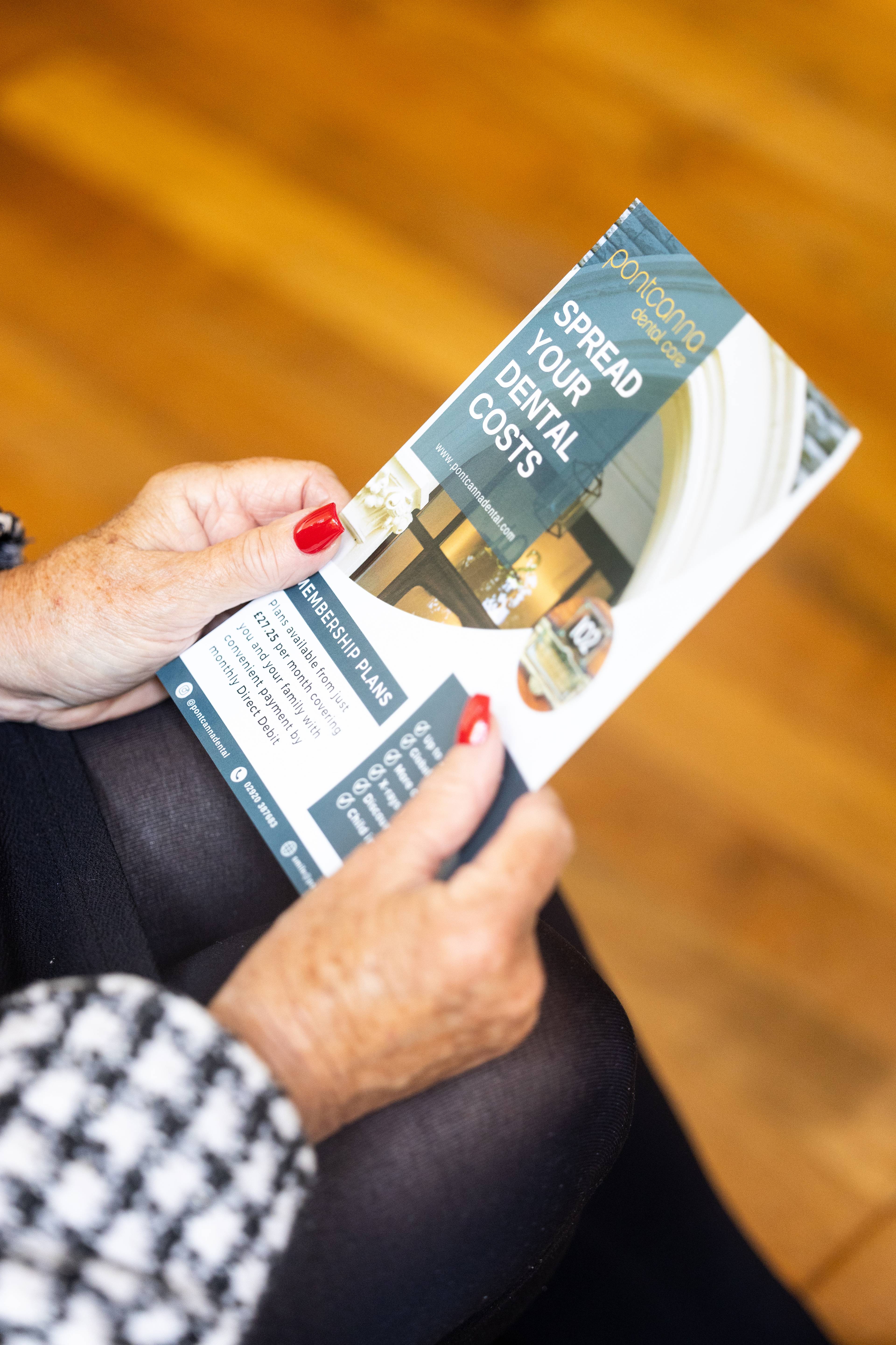 Hands holding Pontcanna Dental Care leaflet about spreading the cost of dental care