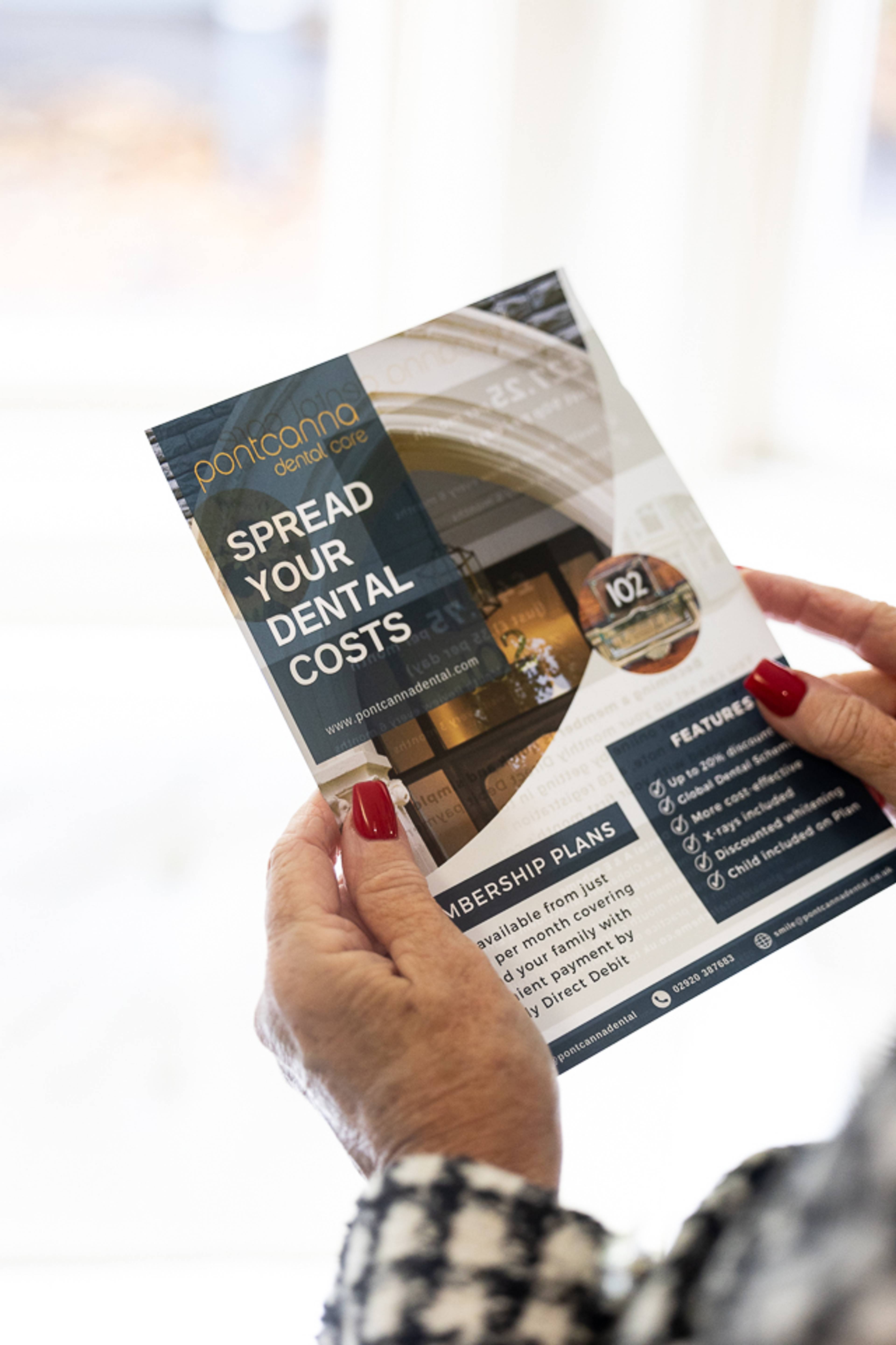 hands holding a leaflet about spreading the cost of dental care