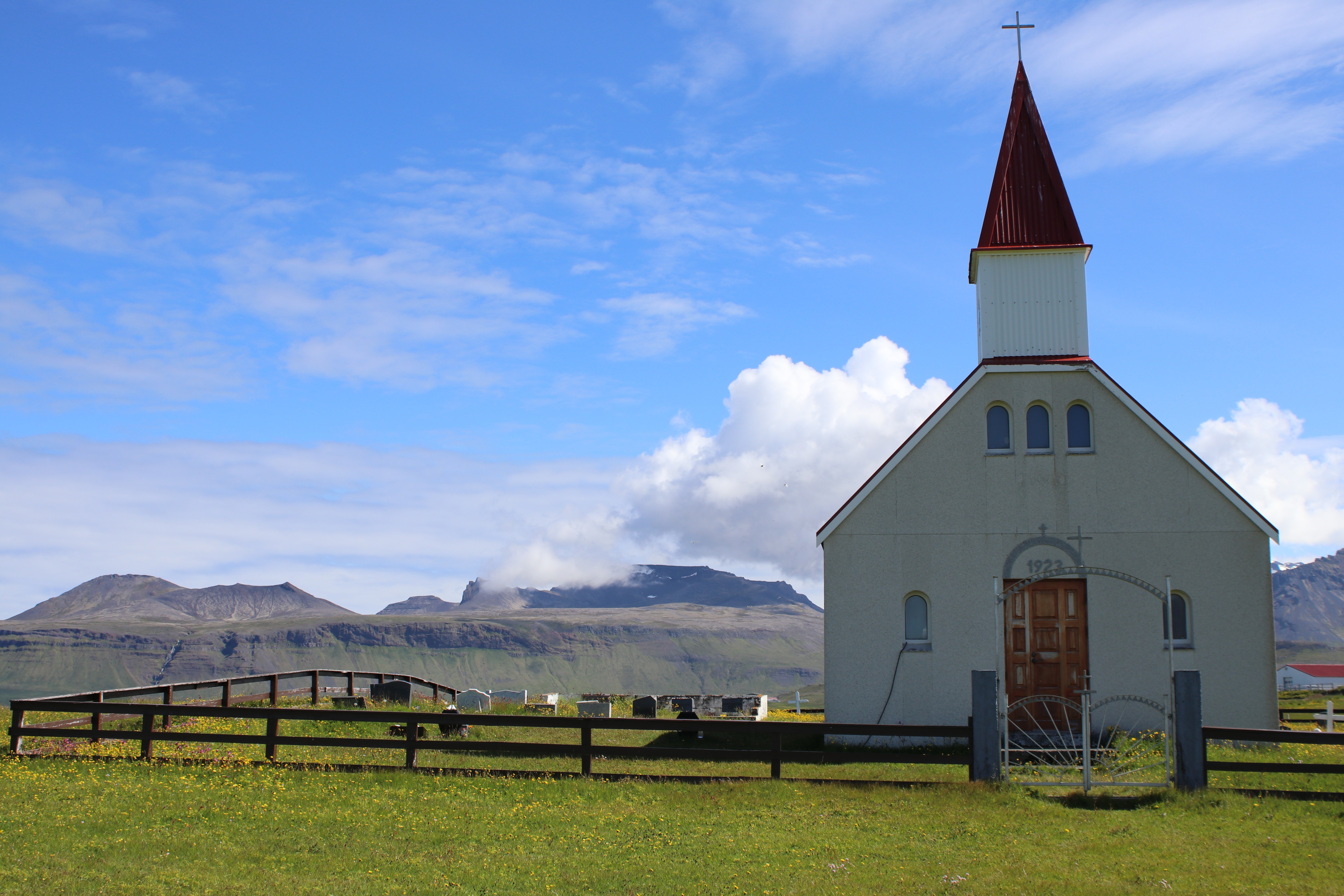 Brimilsvallakirkja með fjöllin í bakgrunni.