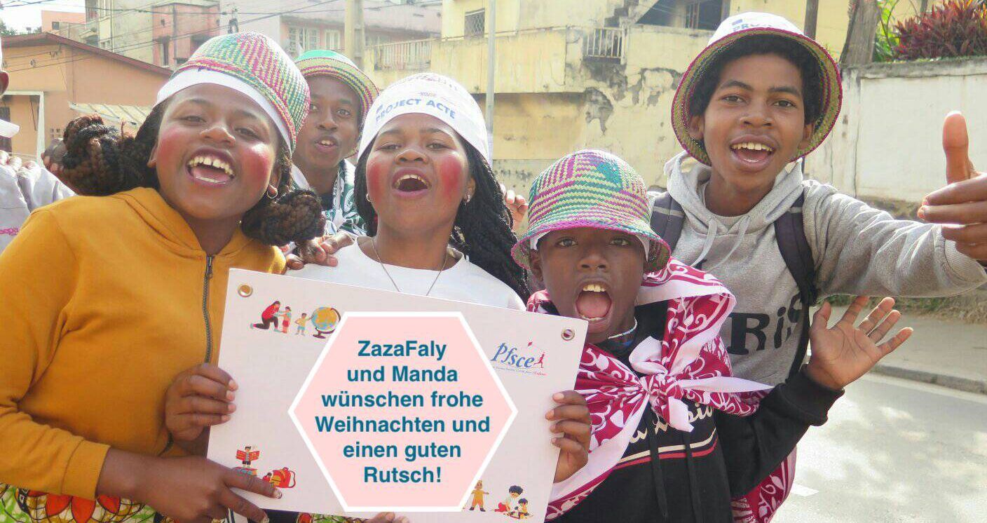Kinder halten einen Weihnachtsgruß von Zaza Faly und MANDA