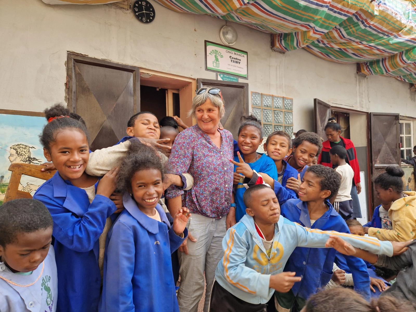 Sibylle Wollschläger steht mit Kindern vor dem MANDA-Gebäude.