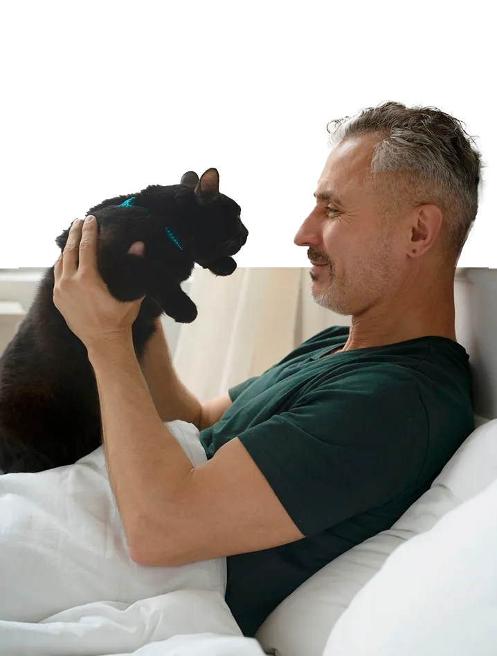 Un hombre tumbado en la cama con un gato negro en su pecho Un hombre tumbado en la cama con un gato negro en su pecho