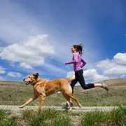 Photo of a woman and a dog running together