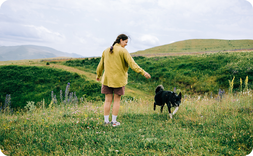 Mujer en el campo acompañada de un perro