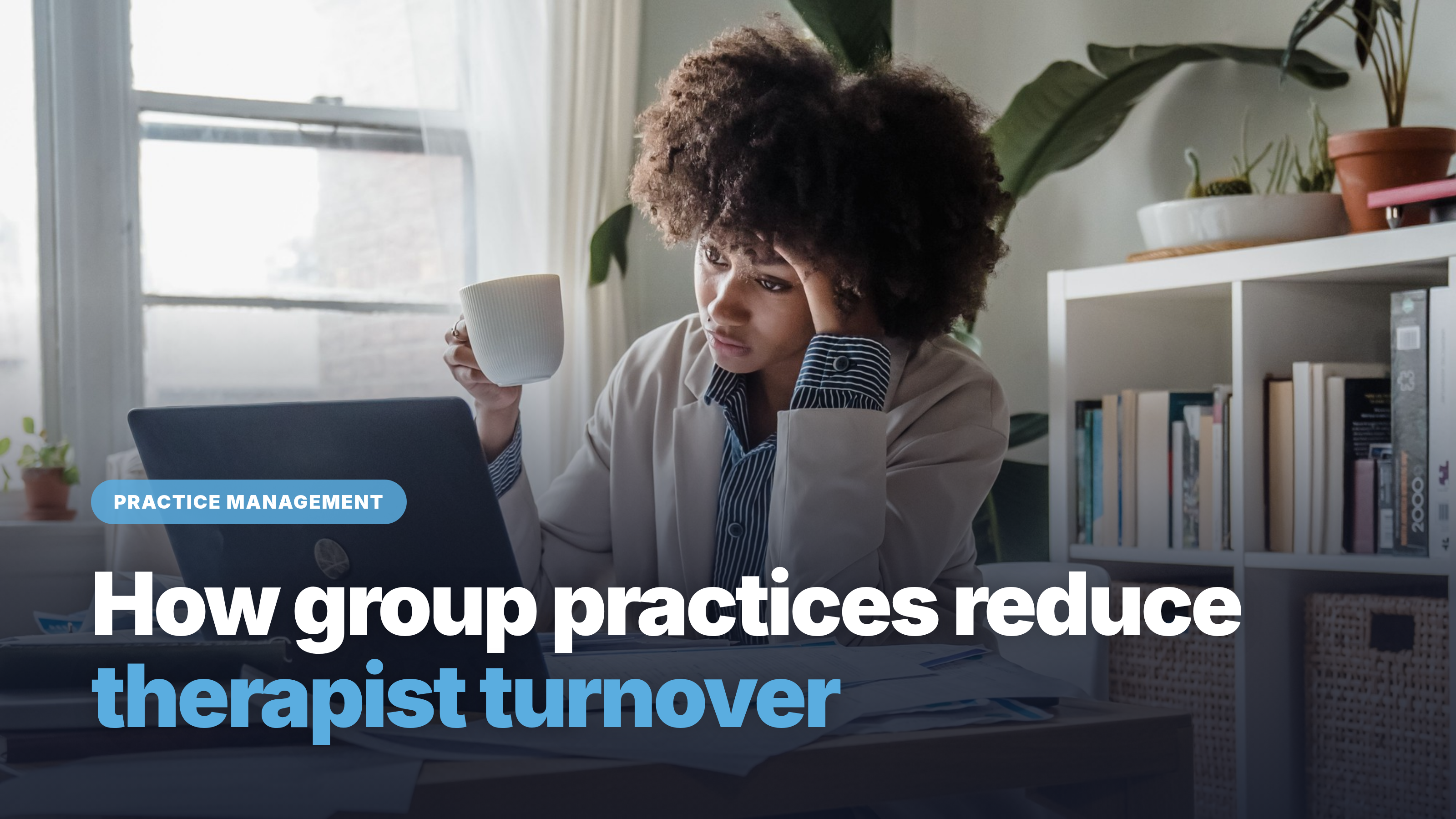 Burned-out therapist at her desk in a group practice office, head in her hand, looking at her laptop, a sign of therapist turnover risk
