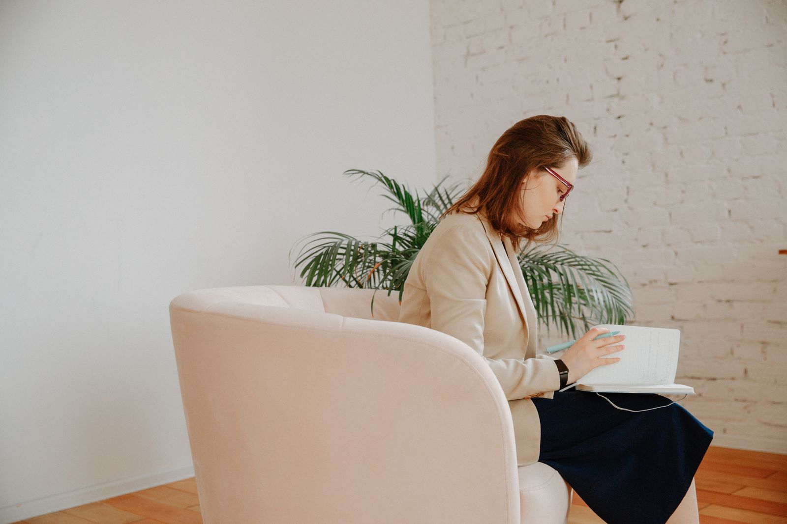 A therapist in a bright office reviews a client's outcome measure scores and progress notes