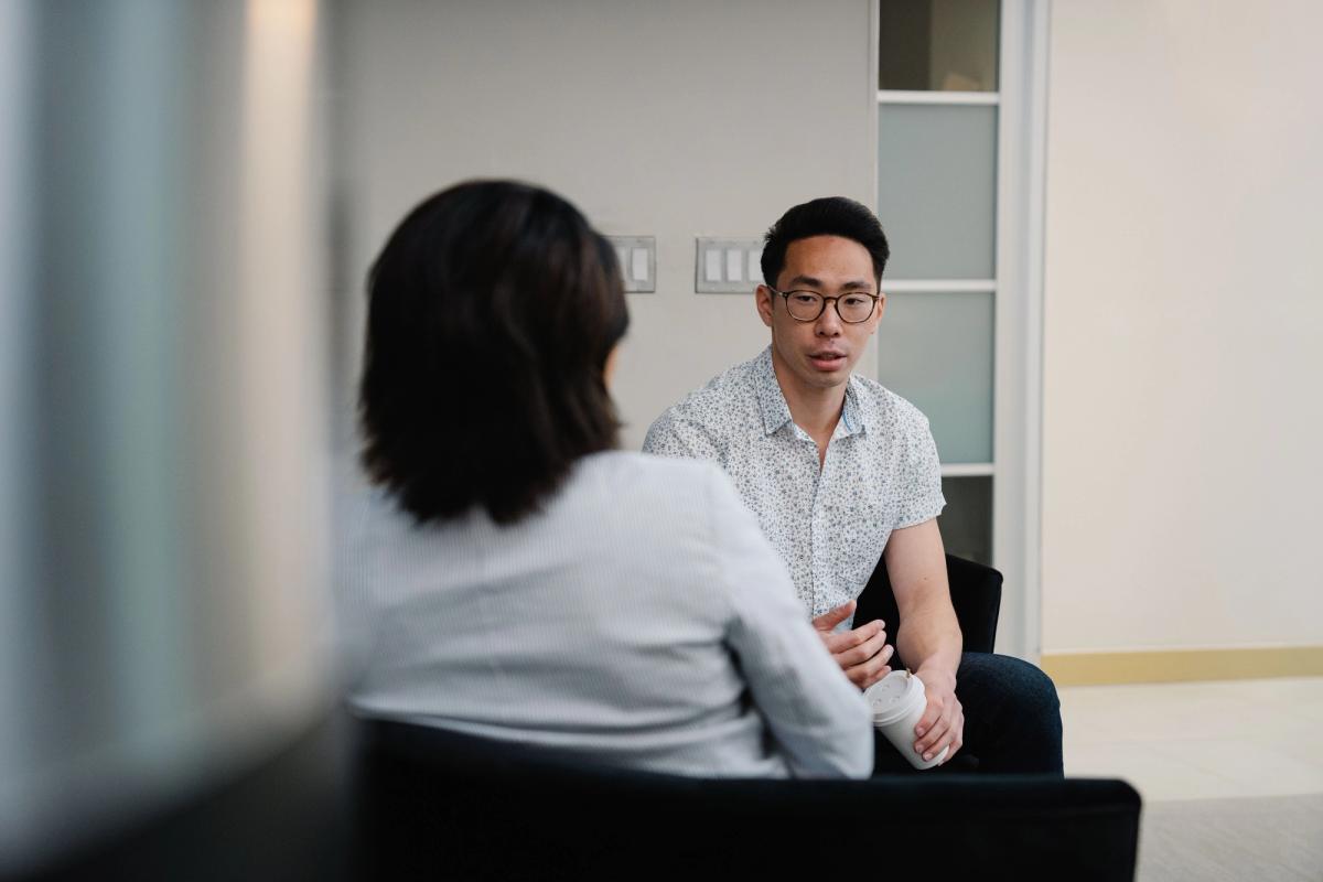 Two clinicians in a quiet one-on-one supervision conversation in a private office