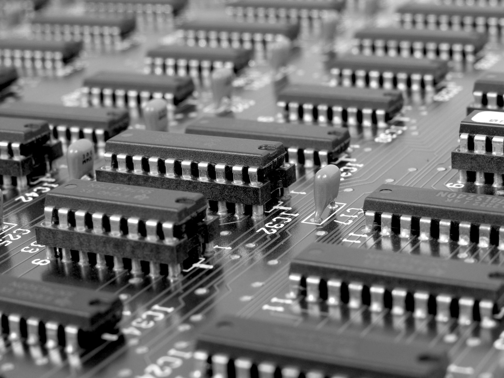 Close-up of a circuit board with rows of black integrated chips and components