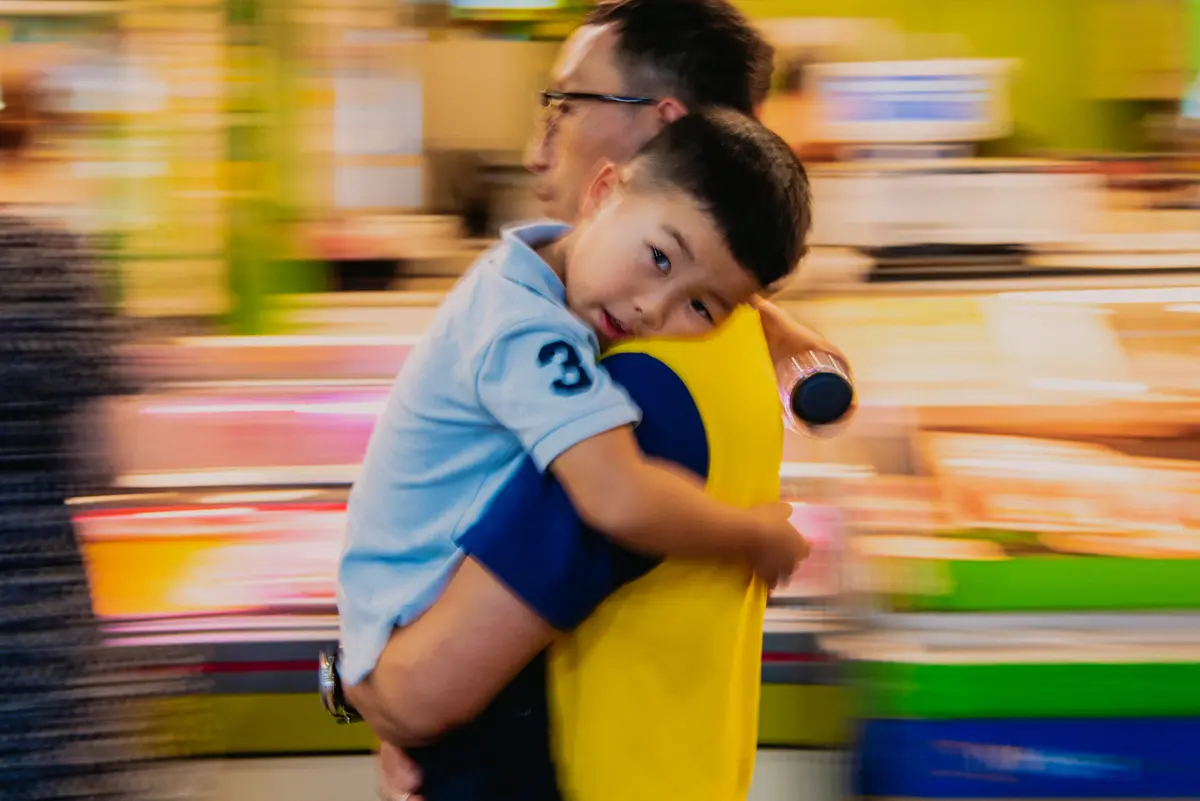 A man carries a boy through Mangwon Market in Seoul