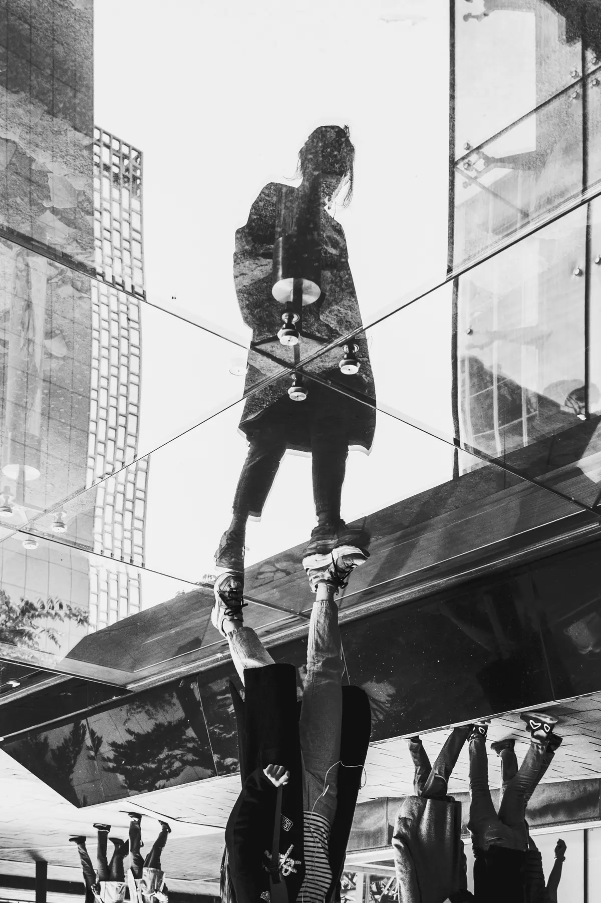 Inverted reflection of a woman walking as city buildings rise behind her