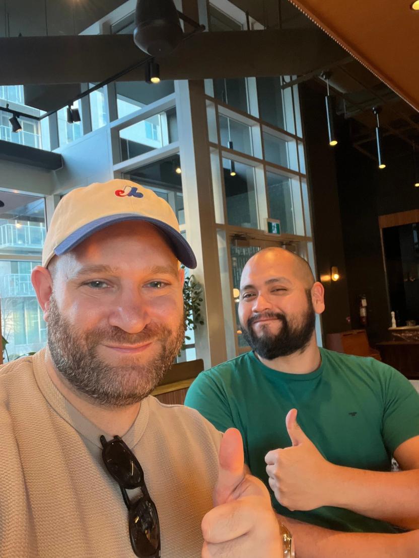 Two smiling Kompas colleagues giving a thumbs up in a selfie
