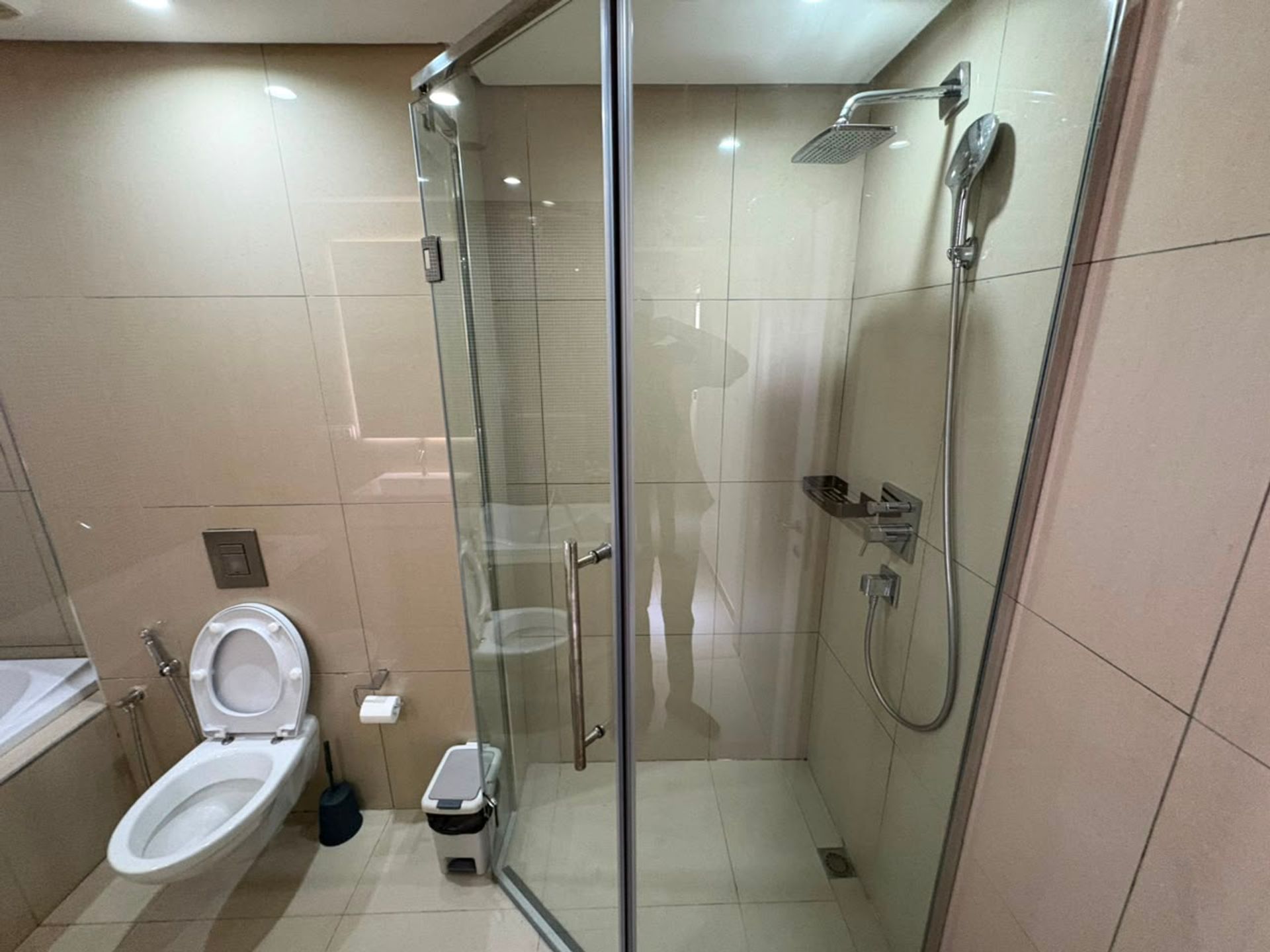 Salle de bain d'un duplex meublé à Mermoz avec cabine de douche en verre, robinetterie chromée et toilettes