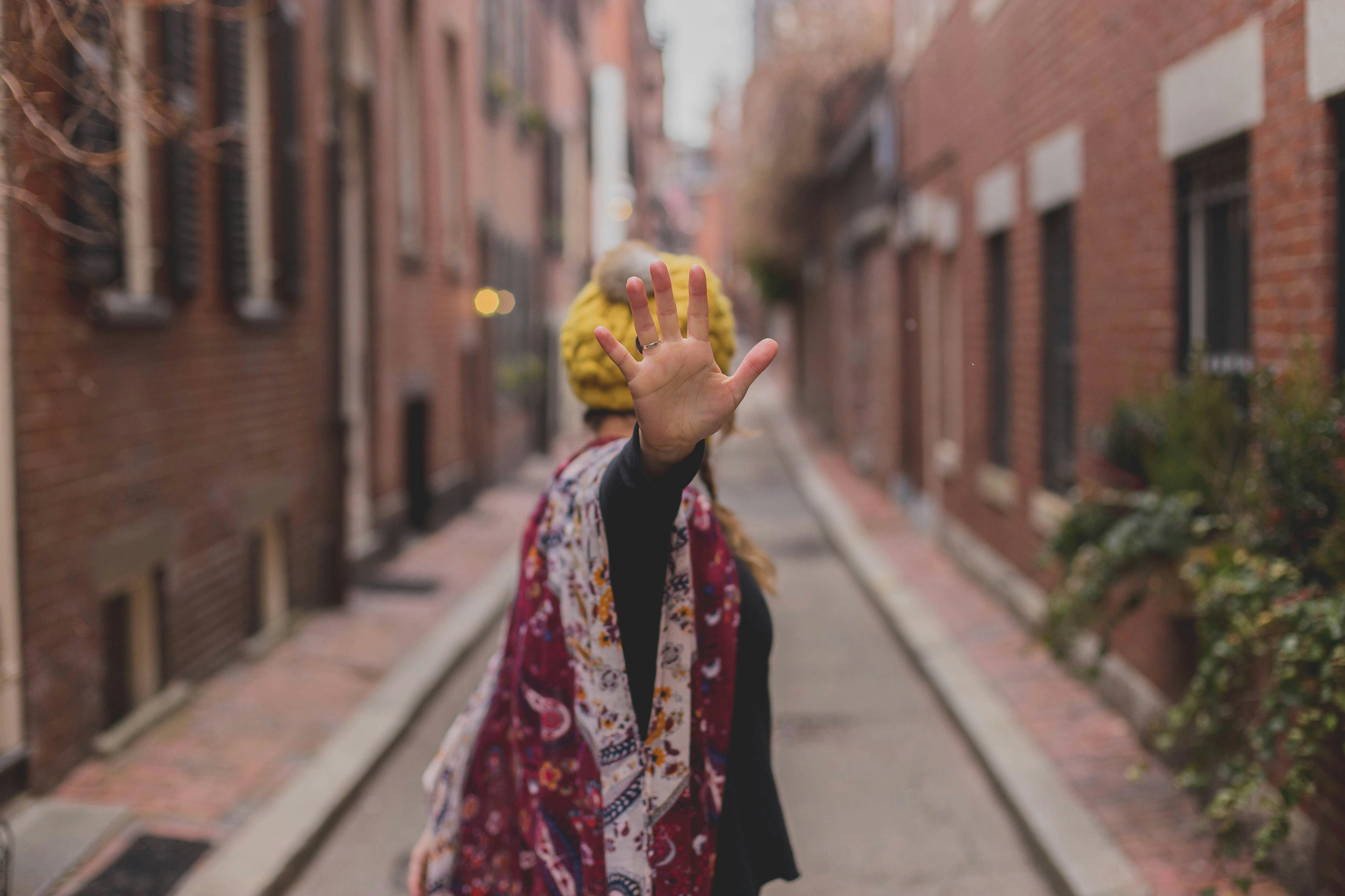 a photo of a woman holding up her hand to say "stop" by Dayne Topkin via Unsplash