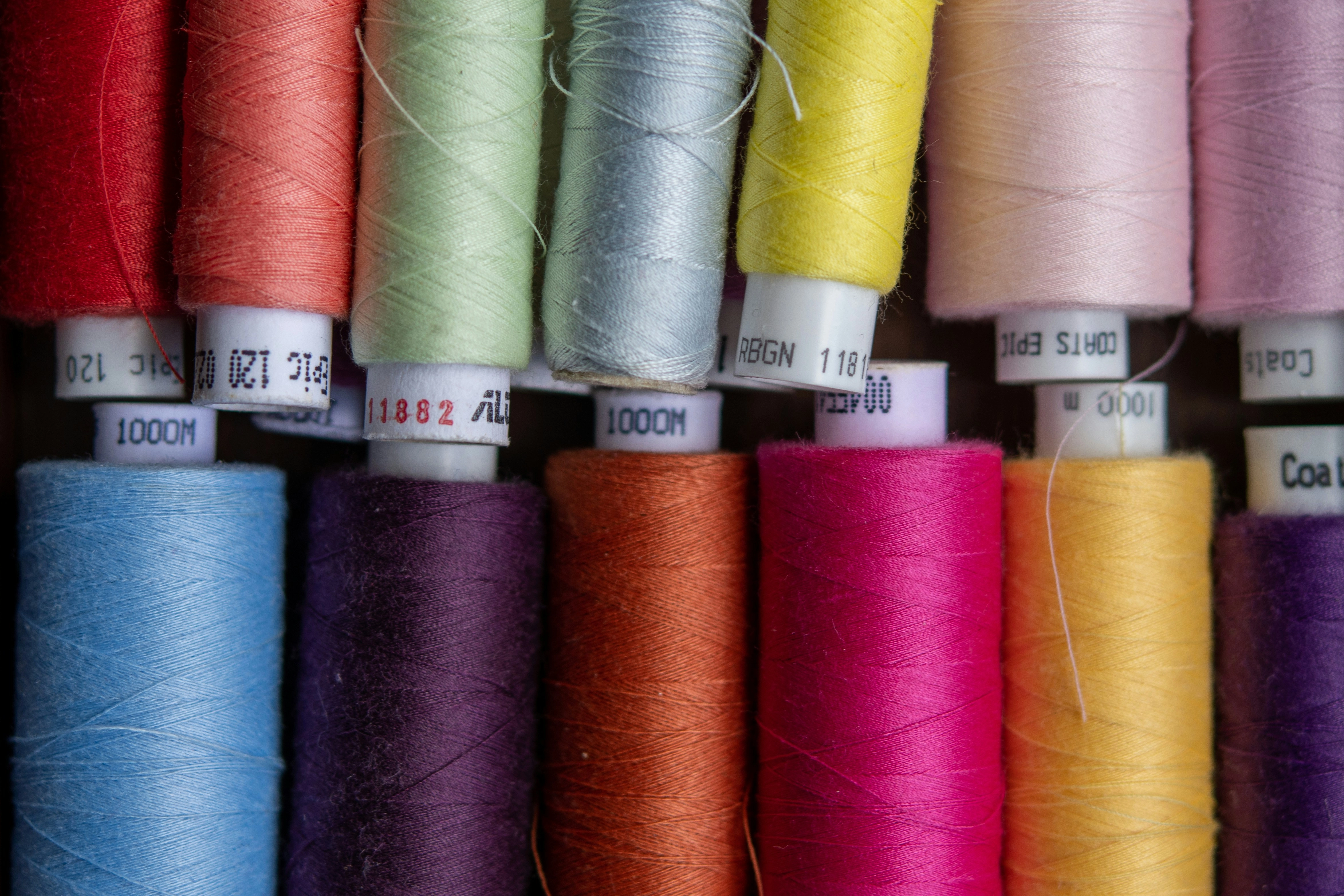 a close-up photo of reels of sewing thread in multiple bright colours by Bozhin Karaivanov via Unsplash