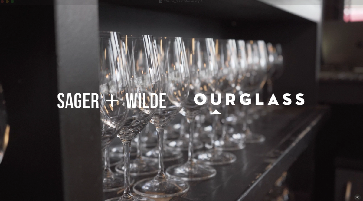 Rows of polished wine glasses at Sager + Wilde, a leading London natural wine bar, with the Ourglass logo overlaid.
