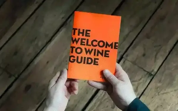 Hands holding Ourglass Welcome to Wine Guide booklet - wine education materials included with wine subscription service