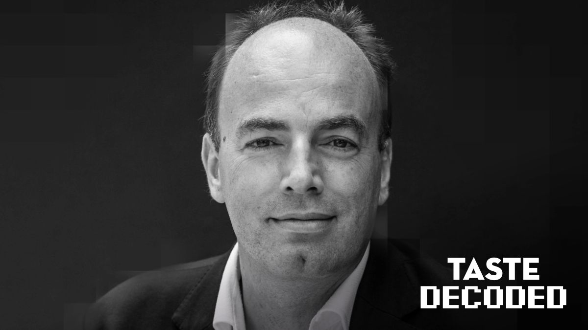 Woman smelling red wine in natural light at a marble table, capturing the sensory ritual of wine tasting in a modern restaurant setting.