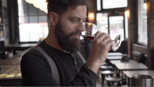 Michael Sager, co-founder of Sager + Wilde, nosing a glass of red wine at his London restaurant for the Ourglass Taste Decoded series.