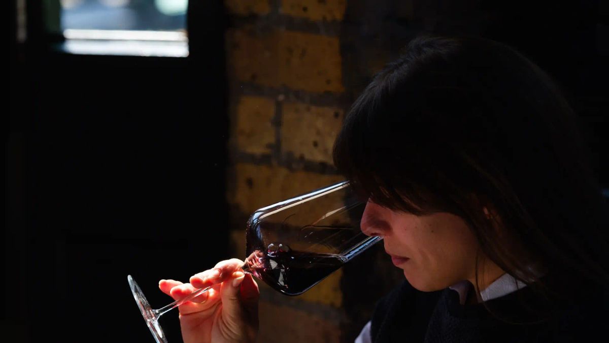 Sommelier Marina at Sager+Wilde, Hackney confidently assessing a glass of red wine in natural light"