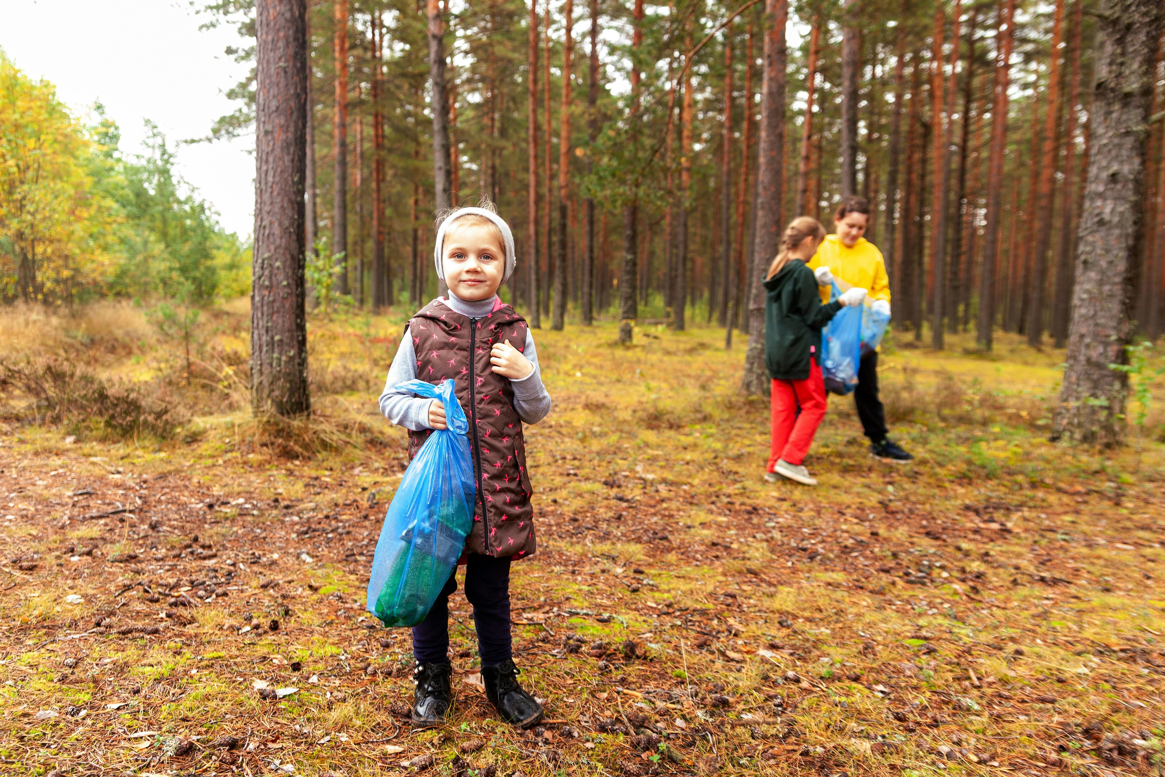 Kids picking up waste in forest