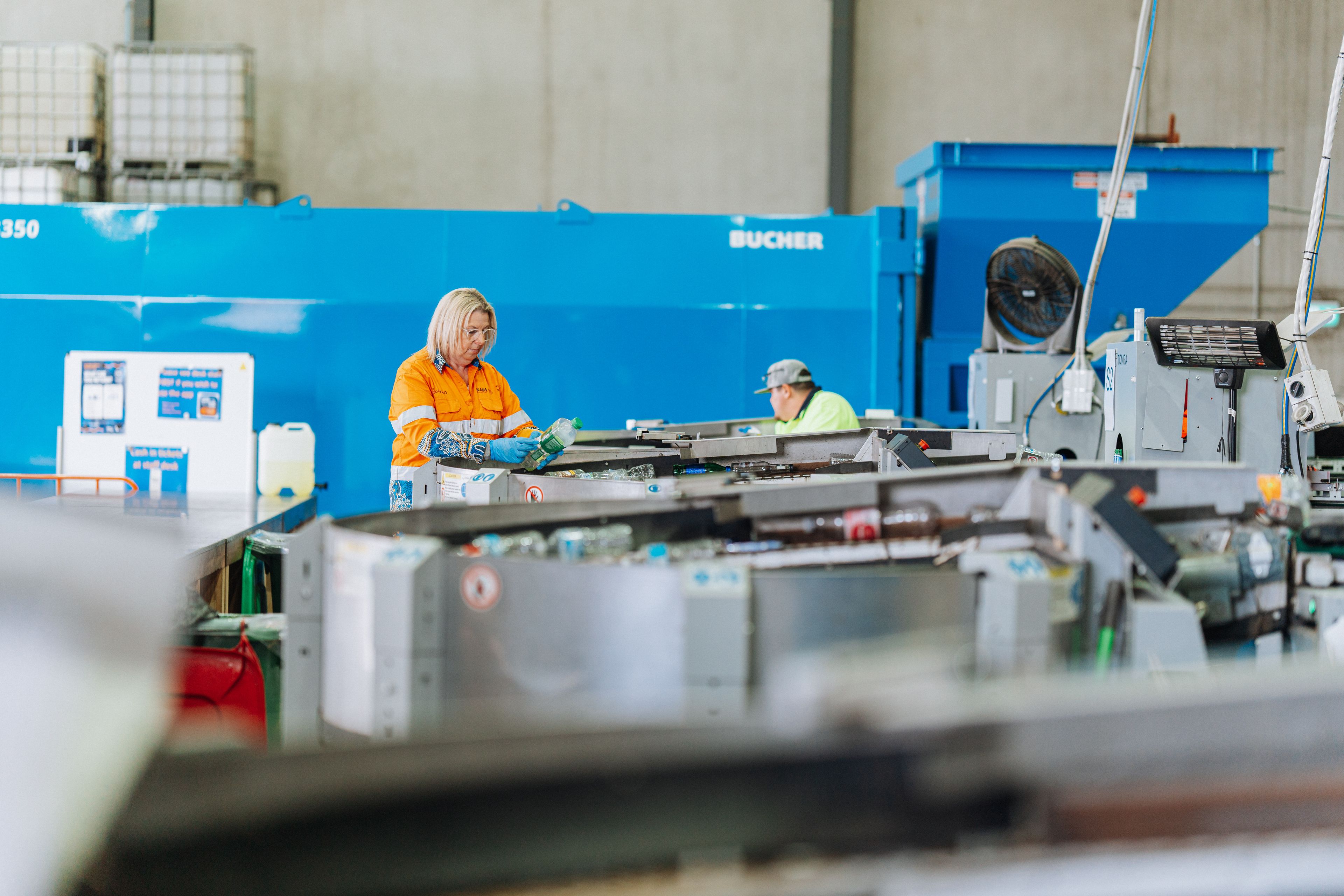 City Return and Earn staff operating recycling machines at the depot