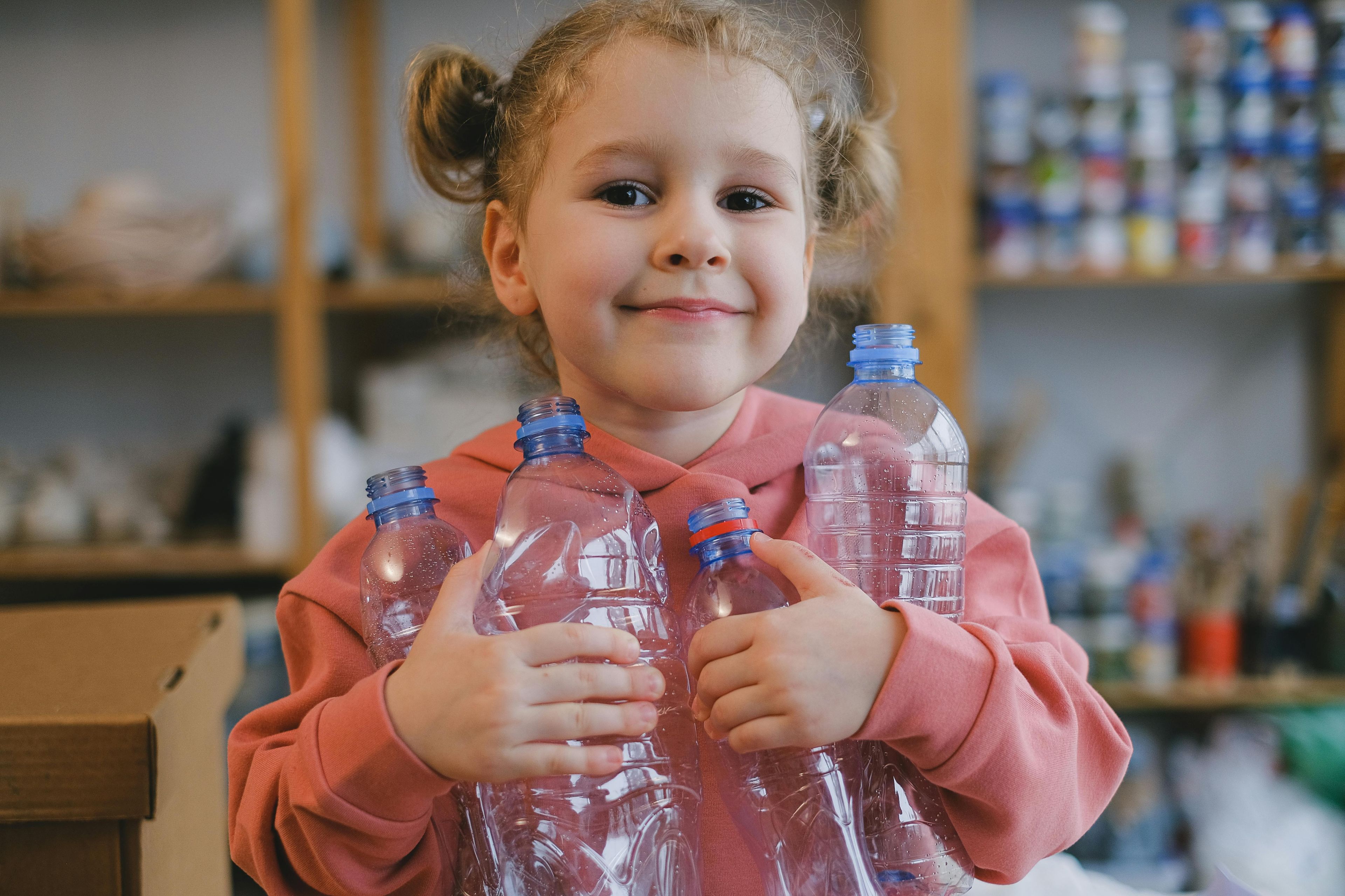 Girl carrying empty plastic bottles for recycling