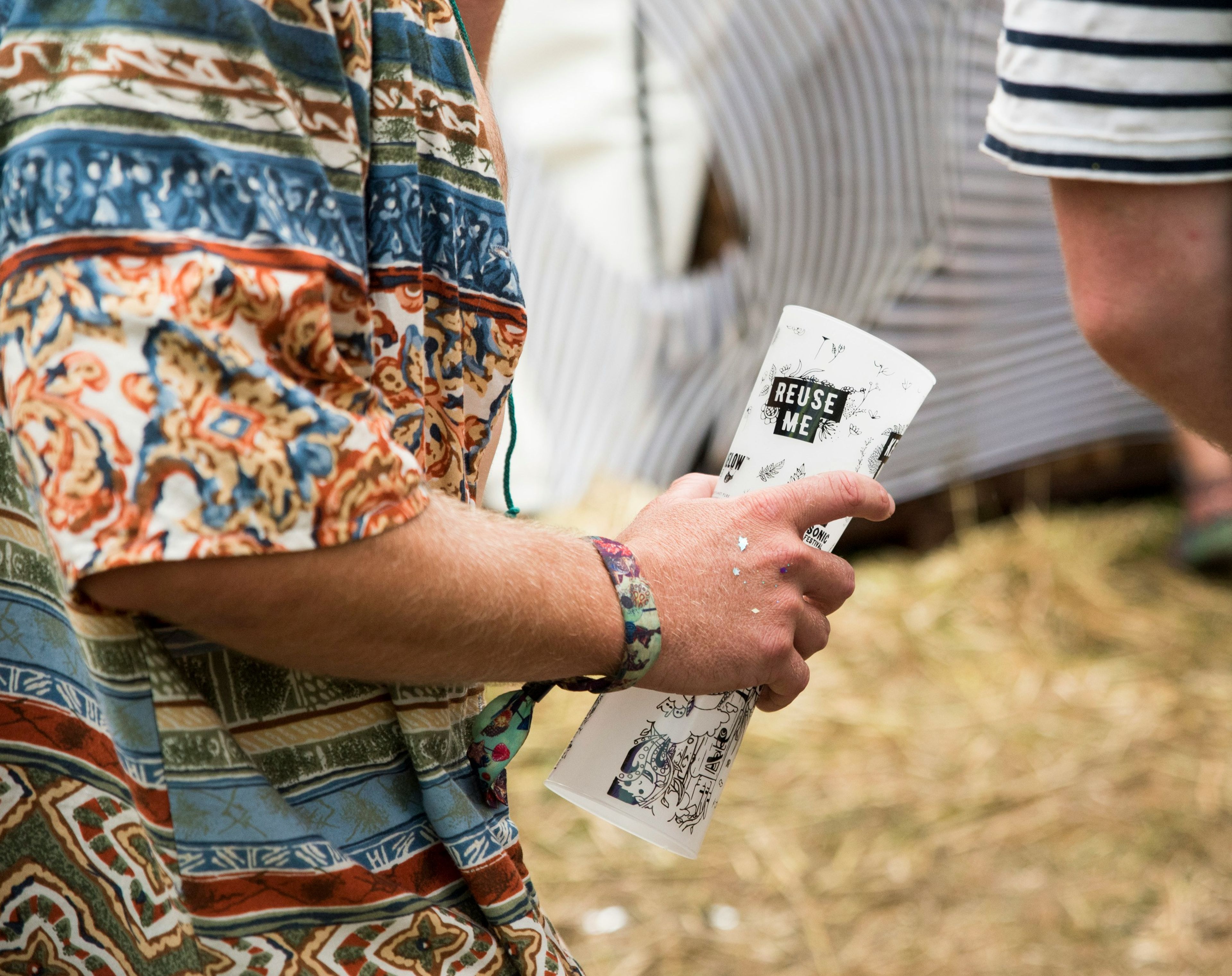 Patron at festival holding 2 reusable cups