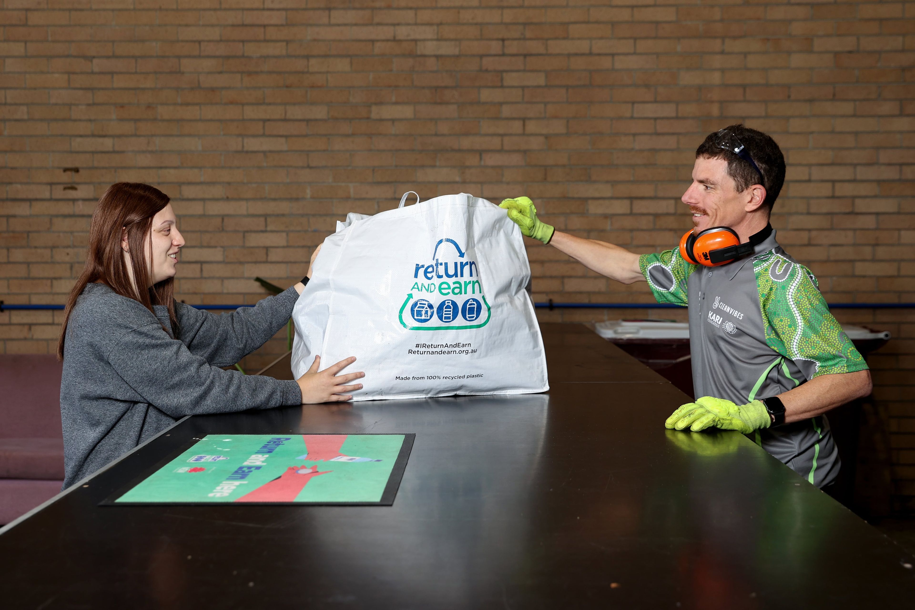 Person handing over return & earn bag over counter