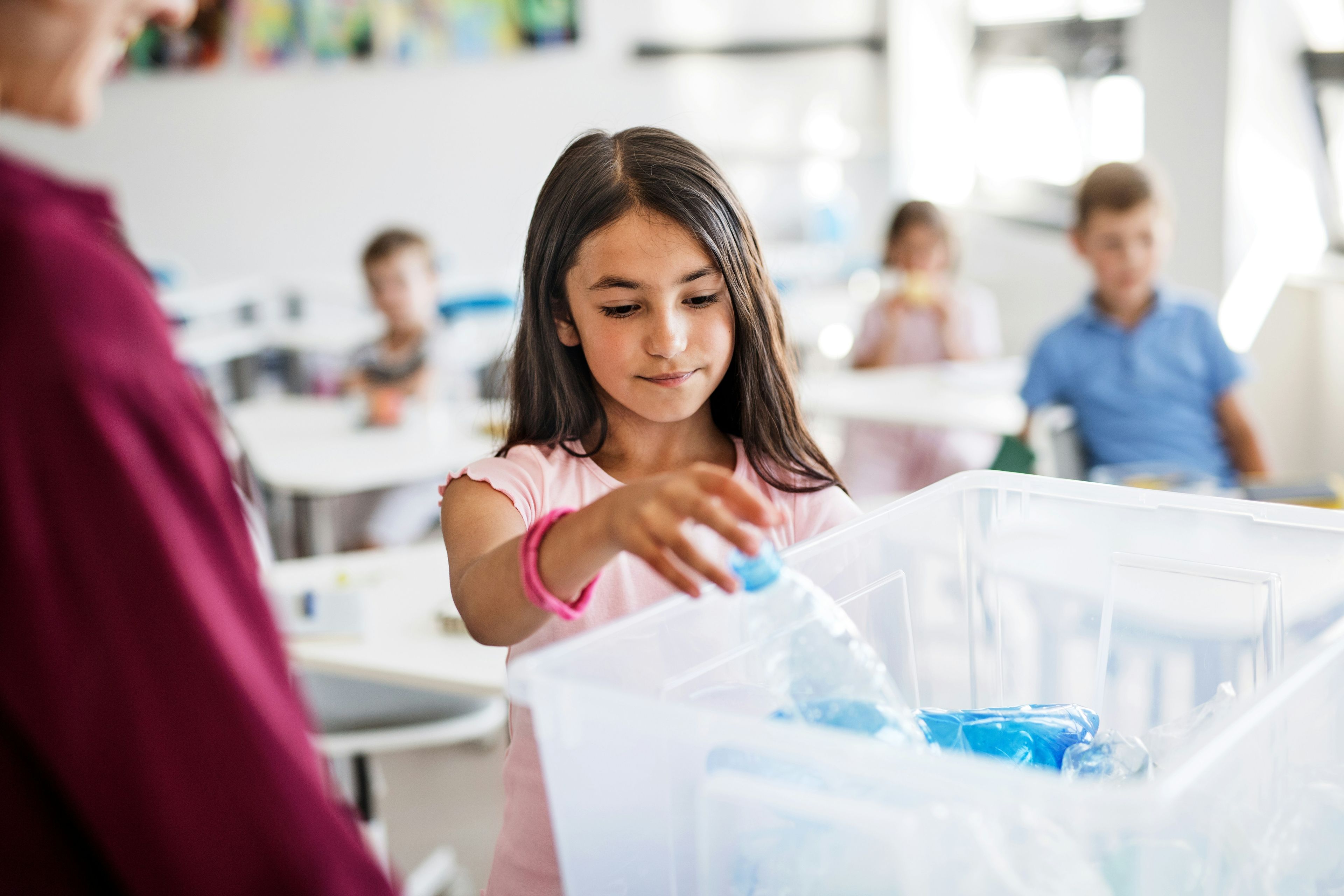 School kid recycling plastic bottle