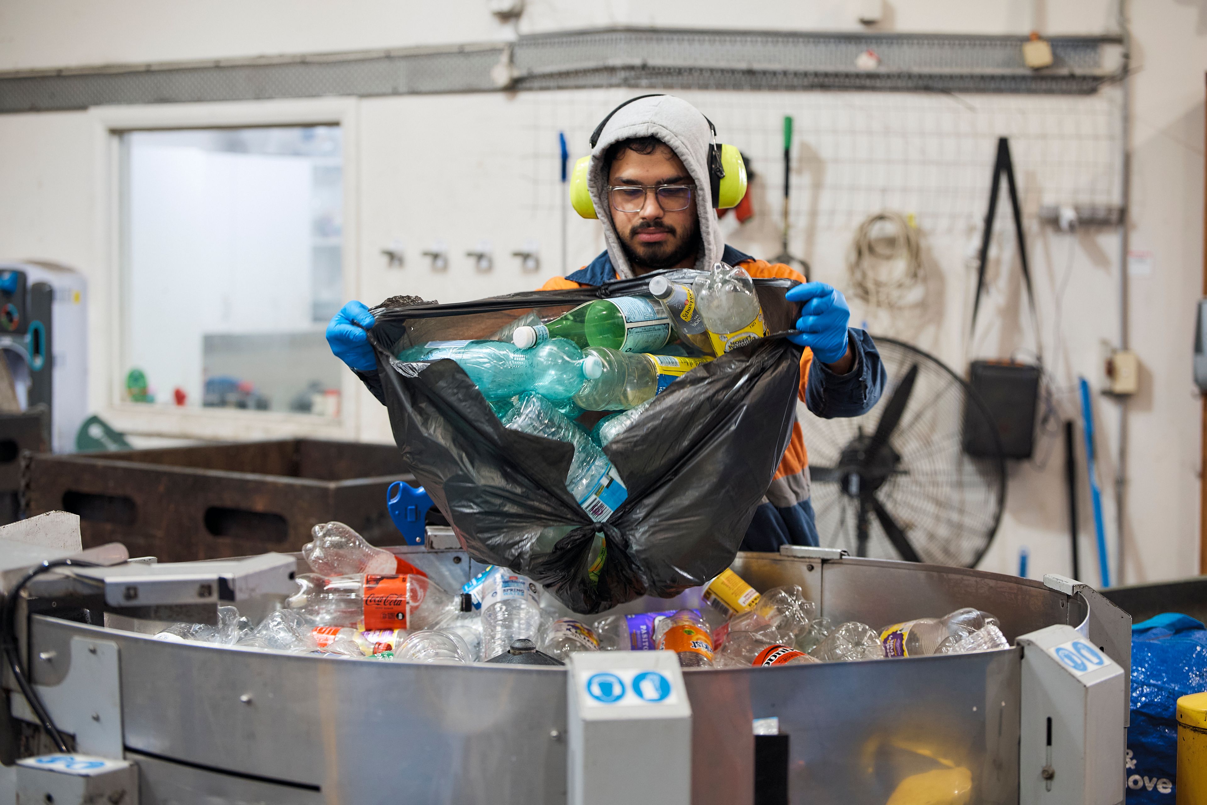City Return & Earn staff recycling plastic bottles